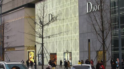 Chengdu,Sichuna China, Jan,31,2018: time lapse of people walking  at IFS with Dior and LOUIS VUITTON Sign on the wall  downtown Chengdu ,Sichuan China