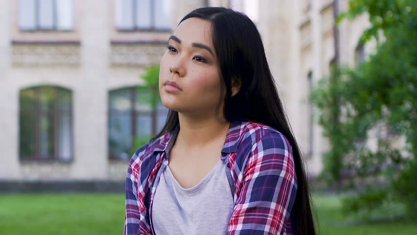 Asian girl sitting alone and looking around, dreamy personality, thoughtful