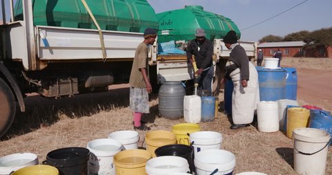 Poor people in Africa unable to maintain social distance due to water crisis Water hardship. African people collecting water in containers from a remote water tanker due to severe drought in  Africa