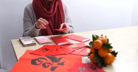 Putting money into chinese red packet for lunar new year : vidéo de stock