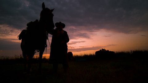 Cinematic landscape silhouette of cowboy & his horse 