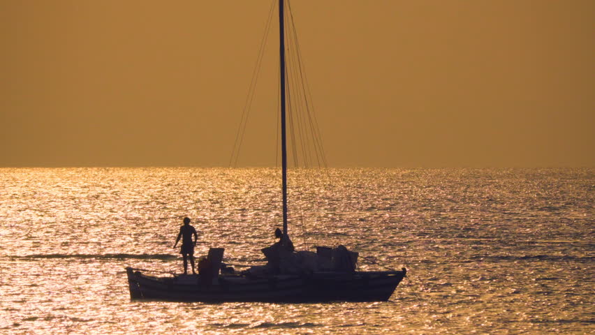 Yacht catamaran with couple  silhouette  in the sea at sunset. Long shot