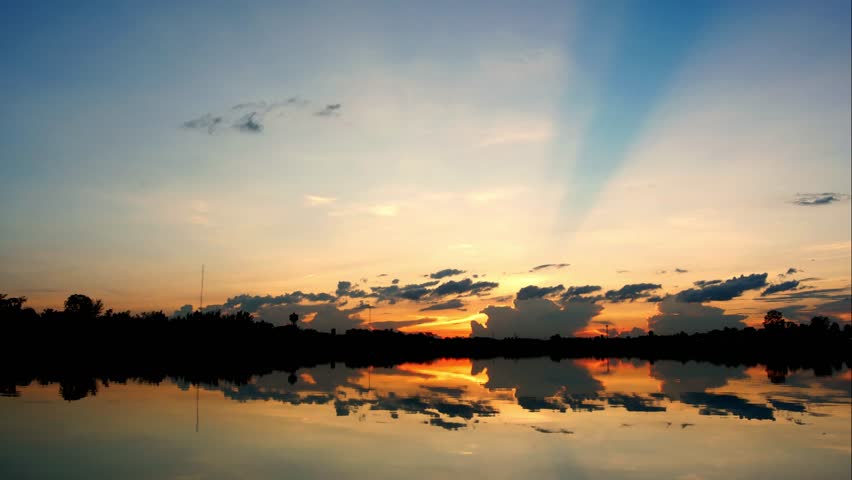 Apocalyptic dramatic clouds and sunset over lake, time-lapse. 