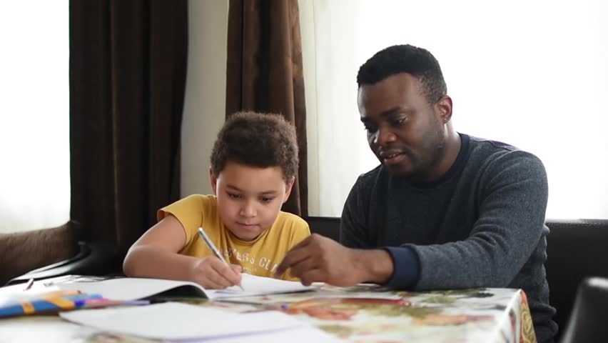 Mixed family at home. African father and african american child. dad helping son with school homework. Education and relationship, man teaching and boy learning. home schooling.
 Royalty-Free Stock Footage #1006992934