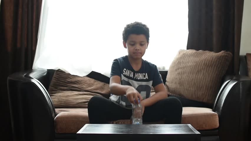 Cute mixed boy doing bottle flip challenge at home and after making dab. Children have a fun. African american kids bottle fun.  Royalty-Free Stock Footage #1006997779