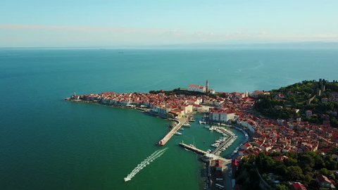 4K Compilation Video. Flight over old city Piran in the morning, aerial top view with Tartini Square, St. George's Parish Church, marina and roofs of the old houses.