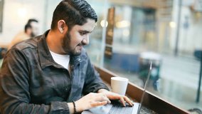 Man using laptop in cafe. Video footage. Hispani? latin handsome
 brunette