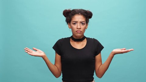 Confused african woman in t-shirt does not know something over blue background