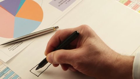 Businessman draws  flowchart on the background of documents