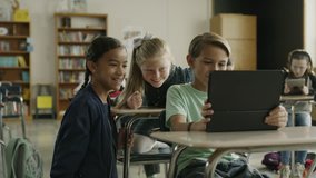 Girls laughing at boy watching digital tablet then surprised and running / Provo, Utah, United States - Powered by Shutterstock - Get 15% off with code: PIKWIZARD15