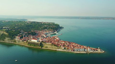 4K Compilation Video. Flight over old city Piran in the morning, aerial view with Tartini Square, St. George's Parish Church, marina and roofs of the old houses.