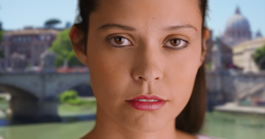 Close up of Caucasian female in Rome looking at camera. Portrait of beautiful woman tourist standing outdoors. 4k