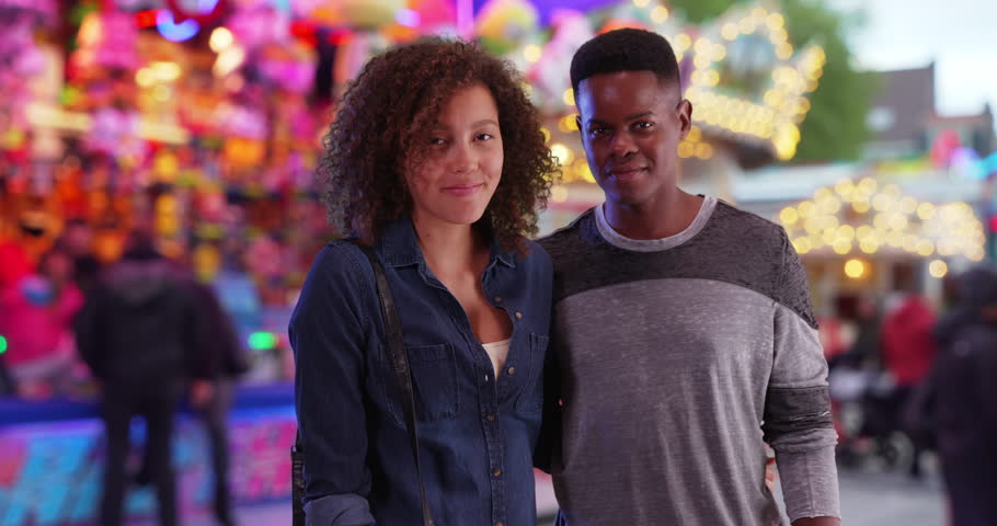 Happy African American couple pose for a portrait at the county fair. Millennial black male and female at carnival hug and smile at camera. 4k | Shutterstock HD Video #1007022859