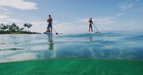 Family stand up paddle boarding in the ocean, active lifestyle
