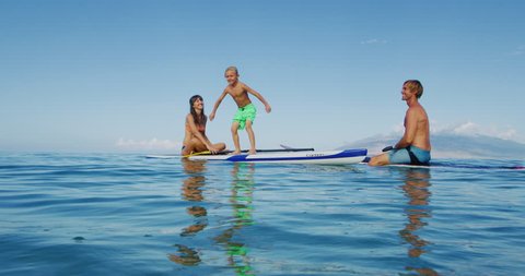 Family stand up paddle boarding having fun in the ocean