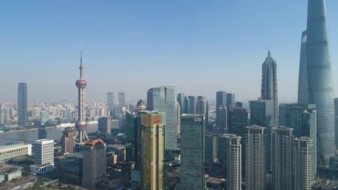 Shanghai, China - January 12 2018: Panning over Lujiazui Financial District in Shanghai. Skyline and Huangpu River at Sunny Day. Aerial View. Establishing Shot.
