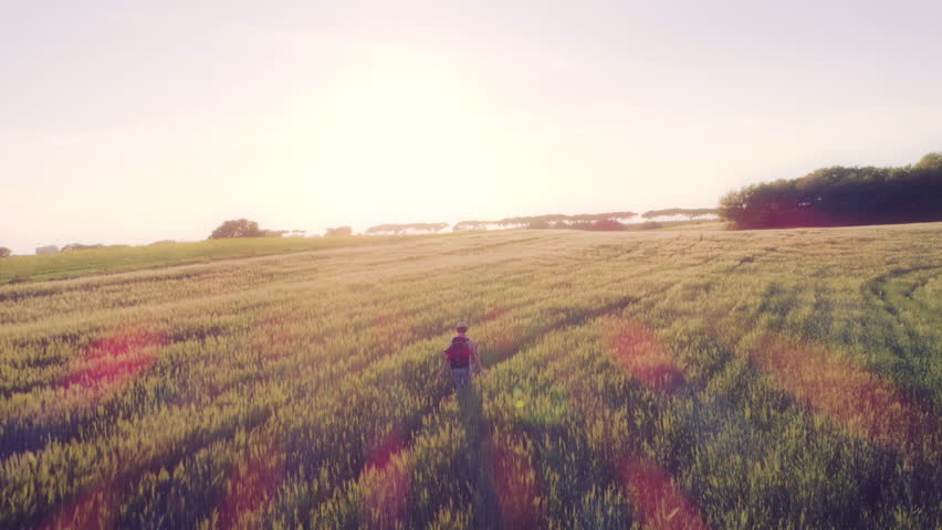 Woman with Backpack walking through farm fields