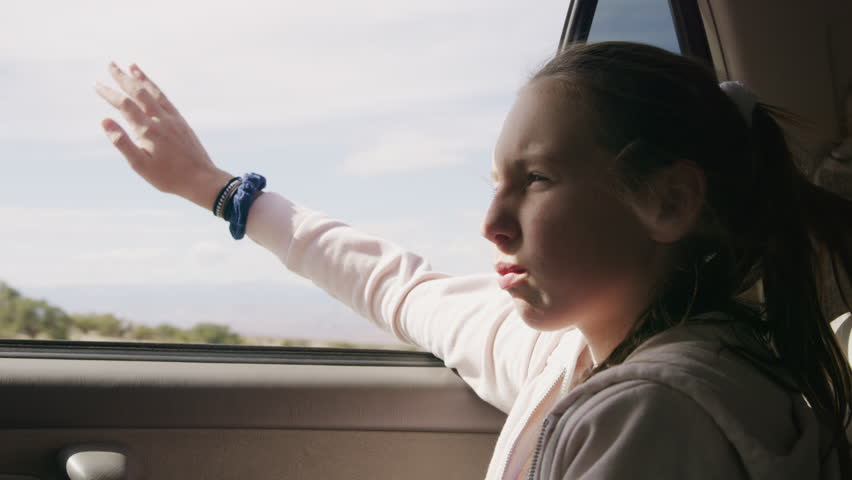 Girl in car with arm outstretched enjoying wind / Moore, Utah, United States