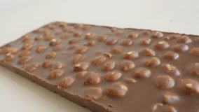 Close-up of high quality tasty dessert slow pan 4K 2160p 30fps UltraHD tilting footage - Opened milk chocolate with whole hazel nuts close-up 3840X2160 UHD panning video