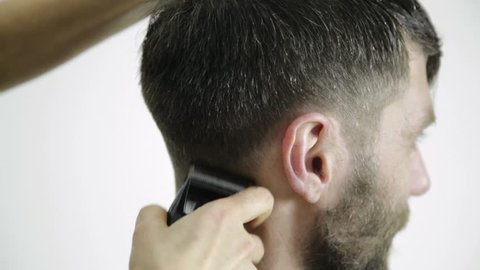 Haircut at barbershop. hairdresser uses scissors for cutting a man. Female hairdresser shaping mens hair cutting uses scissors