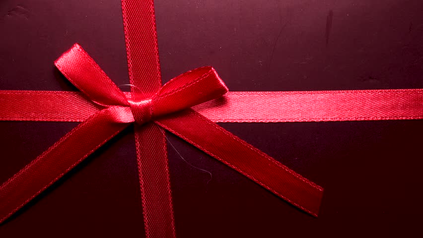 PIECES of CHOCOLATE in a GIFT BOX.  PINK HEART SHAPE background.