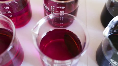 Metal plate of circular shape lying in the potassium permanganate solution, the solution has a different degree of concentration. The forced aging of the metal in a solution of oxidizing chemical. 