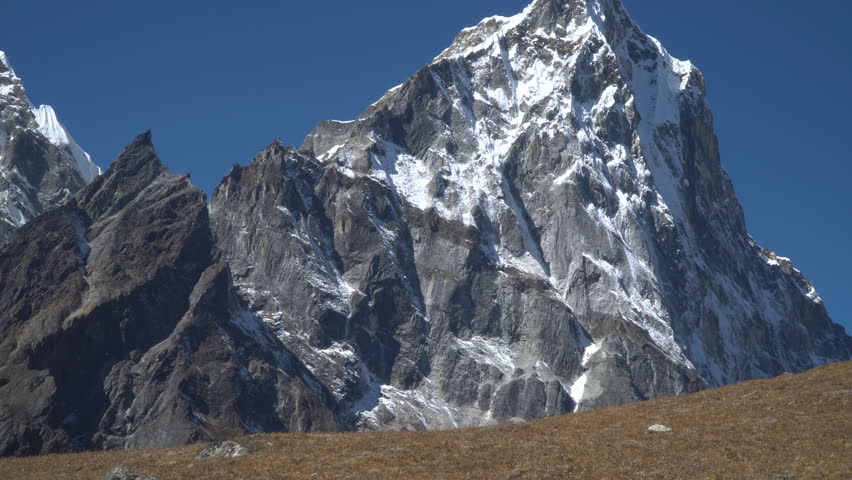 The girl is traveling in the mountains. Beautiful view of the snowy peaks. The concept of travel and adventure. Himalayas. 4K