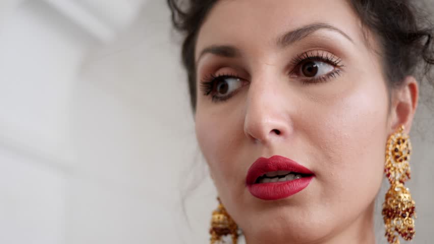 portrait of an elegant young woman with red lips in beautiful chic earrings close-up