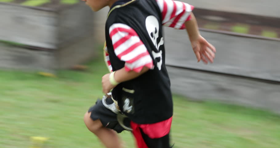 Young boy wearing pirate costume runs in the outdoor garden in 4k