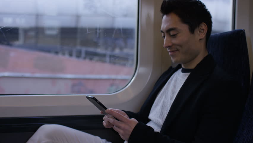 Confident man on a train journey using his phone, in slow motion Royalty-Free Stock Footage #1007079562