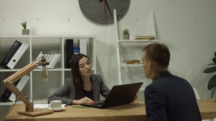 Beautiful brunette female human resource manager interviewing male job applicant at desk in office. HR manager reviewing good cv of prepared skilled applicant and making hiring decision Royalty-Free Stock Footage #1007080207