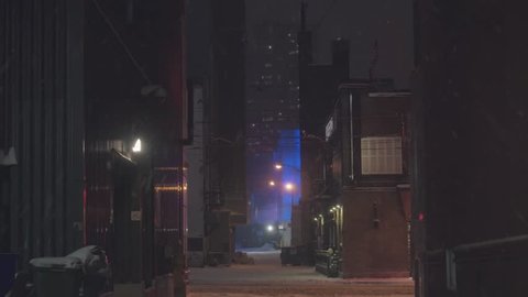 Dark alleyway in winter with futuristic building in the distance