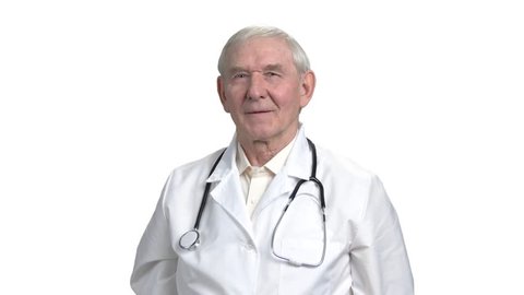 Physician is advising to take vitamins pills. Senior old grandpa pointing at the pills with thumb up in white isolated background.