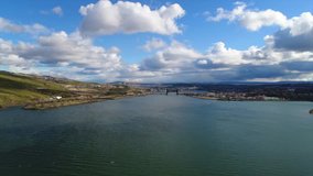 Scenic aerial shot moving backwards at the river confluence on a partly cloudy day