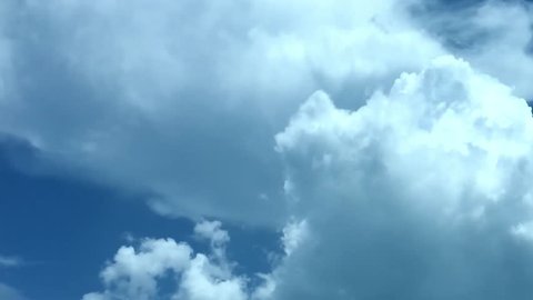 Puffy fluffy white clouds blue sky time lapse motion background. Bright blue sky, cloudscape cloudy heaven. Loop of beautiful weather. Fast moving UHD real video. NOT CG. 4K.