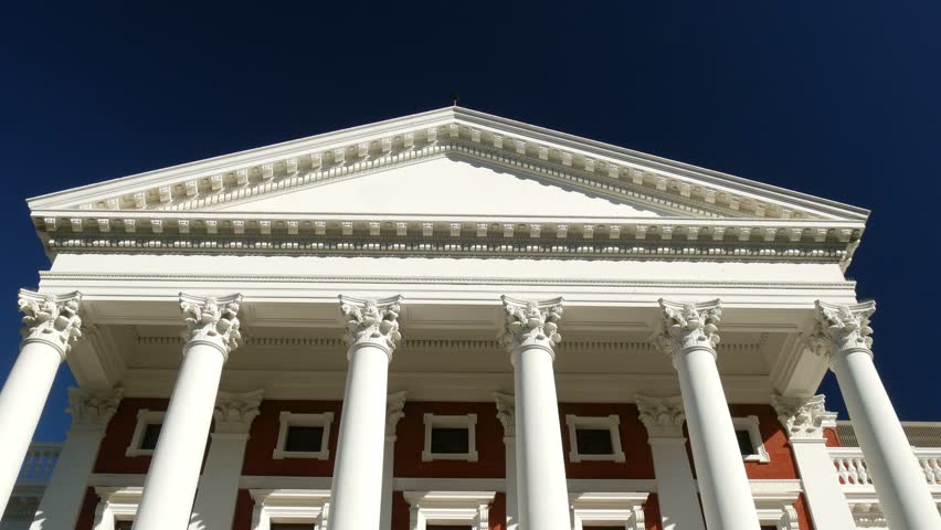 Parliament building white neo-classical pillars view from Cape Town Company Gardens tilt shot 