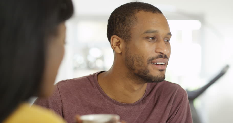 4K Close up handsome African American man chatting to his partner at home. Slow motion.