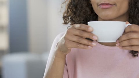 Biracial girl drinking tea and refusing sweet cake, dieting and healthcare