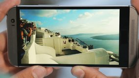 Mobile phone screen showing obstacle jumping on Santorini, parkour, slow motion