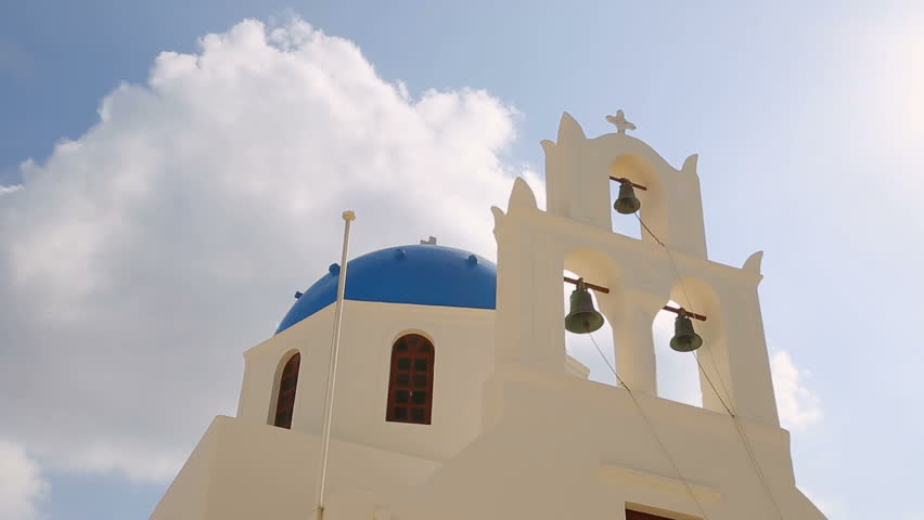 White church against blue sky with bell tower, orthodox Christianity Greece