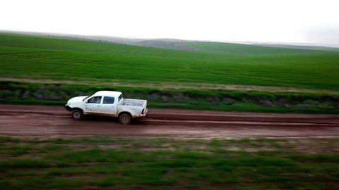 Pickup truck driving quickly on a muddy track