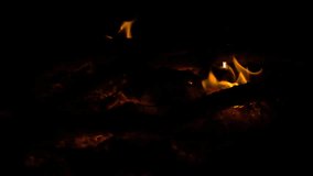 Diminishing yellow fire on hot coals at night, slow motion, hd 1080p video clip
