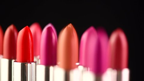 Lipstick. Fashion Colorful Lipsticks rotated over black background. Lipstick tints palette, Professional Makeup and Beauty. Beautiful Make-up concept. Lipgloss. Lipsticks closeup. UHD 4K video