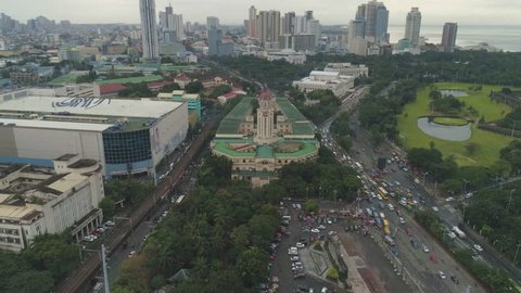 AERIAL: Cinematic Establishing Aerial Shot of the Beautiful Decades old Manila City Hall of Manila, Philippines. Coffin Shape with three-face clock and the largest clock tower of the Philippines