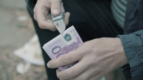 A man holding a knife and money. Preparing the attempt on the life of. Doubt and conscience. Close-up money