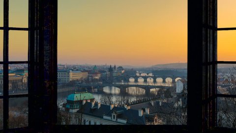 Timelapse of Prague skyline cityscape starting at the sunset ending at night as seen from a window camera moving out the house footage in 4K. Aerial view.