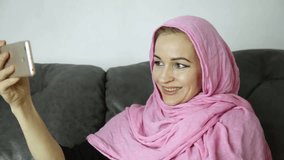 arabian woman wearing a hijab in video chat with her friends on a mobile phone