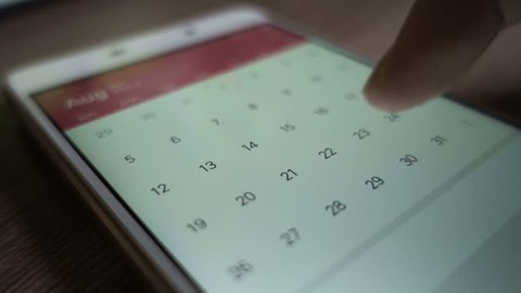  Man using calendar app on the mobile device closeup. Close-up male hands scrolling screen on smartphone.
