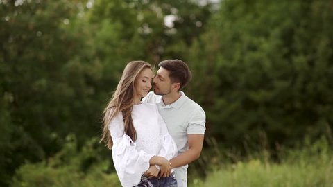 Beautiful Couple In Love Embracing In Nature. Portrait Of Happy Woman And Handsome Young Man In Hugging And Enjoying Summer On Weekend. People On Romantic Date Outdoors