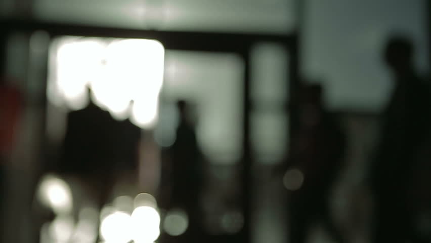Silohuettes of business people walking throug a door defocused, business concepts.